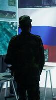 Vertical Military expert from Russian army working in governmental base of operations, breaking into rival states servers to spread fake news and hybrid war propaganda. Brainwashing population. Camera B. video