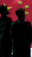 Vertical Cybersecurity specialist in Chinese military command post analyzes data to inflict fear of communism regime. Fake news and propaganda scaring the population, Chinese flag on big screen. Camera A. video