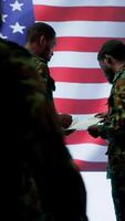Vertical US soldiers in a high tech command center protecting classified information, ensuring cybersecurity and defending against cyber attacks. Army base of operations with trained officers. Camera A. video