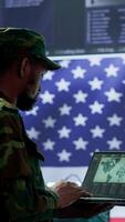 Vertical US soldiers operating in a high tech cybersecurity command post, managing state secrets and classified information. Protecting servers against digital threats and cyber warfare. Camera A. video