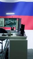 Vertical Empty russian army command center with a big screen showing the national flag, working on spreading fake news and propaganda to inflict fear and misinformation. Terrorist ideology. Camera A. video