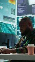 Vertical IT analyst in a high tech base of operations handling surveillance activity and ensuring security protocols. Military command post crew collecting real time data to achieve objectives. Camera B. video