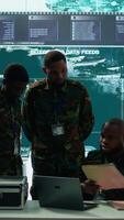 Vertical In a high tech military office, soldiers team analyze real time data collected by surveillance system. Staff interpret intelligence and coordinate operations to ensure national defense. Camera B. video