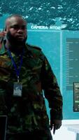 Vertical Military specialist handles national safety operations with his crew in a high tech control center, focusing on data protection and surveillance. Soldiers working on intelligence. Camera A. video