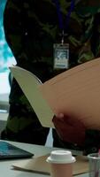 Vertical Angry army expert in a command post power base monitors satellite footage, yelling at soldier and throwing papers. Frustrated officer looks at real time data for operational success. Camera A. video