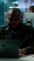 Vertical Army intelligence expert utilizes modern computer systems and satellite radar imagery to enhance national security, strategic initiatives and ensure defense in mission control center. Camera A. video