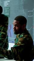 Vertical Government analysts work in an advanced command center with satellite radar systems, overseeing surveillance activities and interpreting real time data. Protecting national interests. Camera A. video