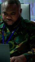Vertical IT analyst in a high tech base of operations handling surveillance activity and ensuring security protocols. Military command post crew collecting real time data to achieve objectives. Camera A. video
