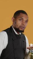 Vertical Professional waiter asking clients to wait a bit before serving them, working in a very busy restaurant. Employee trying to serve customers faster, showing professionalism in catering. Camera A. video