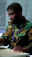 Vertical Military personnel in a control center working on data processing, integrating real time surveillance and security protocols essential for national defense and strategic operations. Camera A. video
