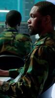 Vertical Military personnel in a high tech command center monitor satellite feeds, coordinate intelligence operations. Maintaining national security and supporting strategic army missions. Camera A. video