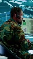 Vertical Soldiers in a modern command center analyze live data from cctv radar sources, satellite feeds and surveillance systems. Intelligence to support strategic planning and military operations. Camera A. video