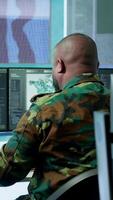 Vertical High tech military office with soldiers analyzing real time data, processing intelligence information and coordinating strategic operations to support army field missions effectively. Camera A. video