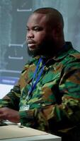 Vertical Government intelligence officer in operation room managing surveillance activity, gathering intelligence to help the troops. Analyzing real time data for national interests protection. Camera A. video