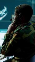 Vertical Army professional in uniform works in a mission control center, coordinating surveillance systems and processing intelligence data for operations. Ensuring strategic planning and defense. Camera A. video