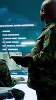 Vertical Cybersecurity team operates in an advanced military command center, surveillance systems and data protection. Army personnel work on national security operations using high tech gear. Camera A. video