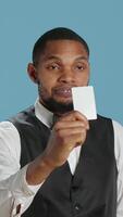 Vertical Hotel concierge presenting the room access key card after check in, providing luxury lodging and amenities at five star holiday resort. Reception personnel gives assistance to guests. Camera A. video