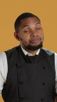 Vertical Professional waiter showing clueless sign and being unsure, shrugging and saying i dont know in studio. Confused butler staff in apron feeling uncertain and doubtful about something. Camera A. video