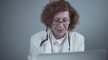 Middle aged woman general practitioner have call with colleagues in office. Doctor talking with patient during virtual medical appointment. Physician talk by online webcam call on laptop. video