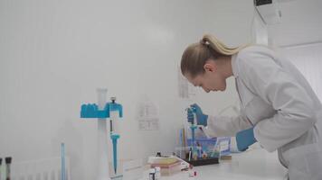 Laboratory technician with dispenser in during blood testing. Medical equipment in the lab. Scientist with a pipette for making hematological test. Researcher in modern laboratory using pipette doser. video