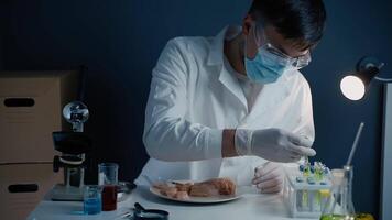 Genetic injection into raw chicken meat. Scientist doing injection to pieces meat. Lab assistant testing GMO chicken. Worker of food quality control. Genetically modified antibiotics residue in food. video