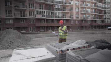 Male builder considers brought building material at construction site, controls materials. Inspector checking and counting building material at site. Supervisor Inspecting insulation for houses. video