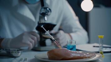 Food quality control scientist works with microscope in laboratory. Syringes with antibiotics in raw meat, injections with genetically modified organisms in chicken, drugs and chemicals in food. video