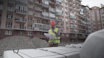 A male construction manager checks the quantity and checks the construction matral with documents at a construction site. Inspector at a construction site at work examines briquettes with insulation. video