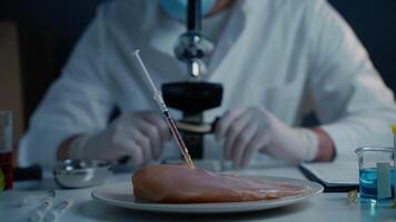 Lab assistant testing GMO chicken. Worker of food quality control examines samples behind a microscope. Genetically modified antibiotics residue in food. Food technology. Food quality control concept video