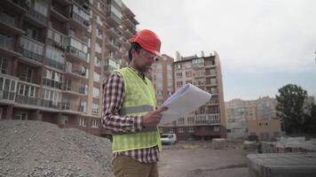 Male builder considers brought building material at construction site, controls materials. Inspector checking and counting building material at site. Supervisor Inspecting insulation for houses. video