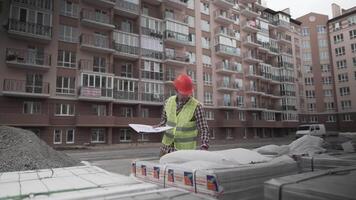 A male construction manager checks the quantity and checks the construction matral with documents at a construction site. Inspector at a construction site at work examines briquettes with insulation. video
