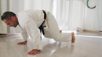 Mann im Weiß Karate Uniform tut Abs Übungen video