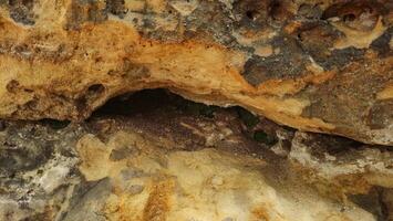 Rock formation with a cave entrance at the top photo