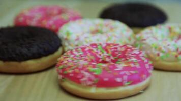 rosquillas en un multicolor vidriar mentira en el mesa. rápido rotación. hd video
