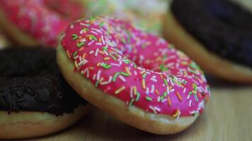 clasificado delicioso dulce multicolor rosquillas mentira en el mesa. de cerca. video