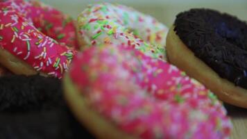 varios delicioso dulce rosquillas mentira en un ligero mesa mesa. video