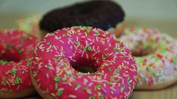 muchos delicioso brillante rosquillas de diferente colores mentira en el mesa video