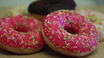 muchos delicioso brillante rosquillas de diferente colores mentira en un ligero mesa video