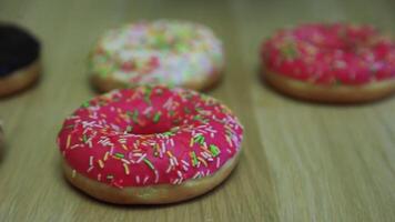 multicolor rosquillas mentira en el mesa mientras ellos son tomado por mano video