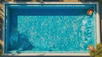 Top view of swimming pool with blue tiles and sun loungers photo