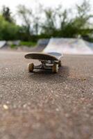 Skateboard Focus Style Life Concept. The skateboard is on the asphalt, the vertical photo is in soft focus.