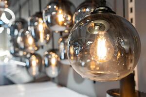 Round glowing tungsten lamp. Vintage tungsten filament multiple lamps of different size and style hanging from the ceiling. photo