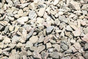 Close-up image of various sizes of grey and pink gravel stones photo