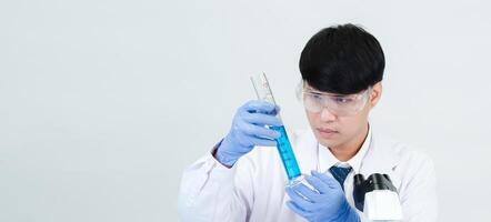 Portrait asian man student scientist wearing a doctor gown in the lab looking hand at chemist. caused by mixing reagents in scientific research laboratories with test tubes and microscope on the table photo