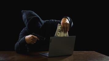 Hacker spy man one person black hoodie sitting hand holding credit card look computer laptop used login password attack security data digital internet network system night dark background copy space photo