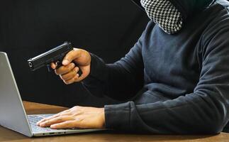 Hacker spy man one person black hoodie sitting hand holding credit card look computer laptop used login password attack security data digital internet network system night dark background copy space photo
