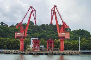 Batam, Indonesia. 7 July 2024. Grab crane, a tool used for loading and unloading cargo from ships. photo
