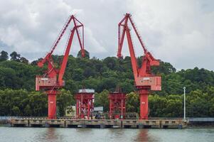 Batam, Indonesia. 7 July 2024. Grab crane, a tool used for loading and unloading cargo from ships. photo