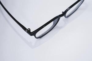 Simple black eyeglass frames with a plain background photo