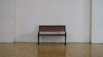 Simple Wooden Bench with Metal Frame in Minimalistic Indoor Setting Against White Wall with Tiled Floor photo
